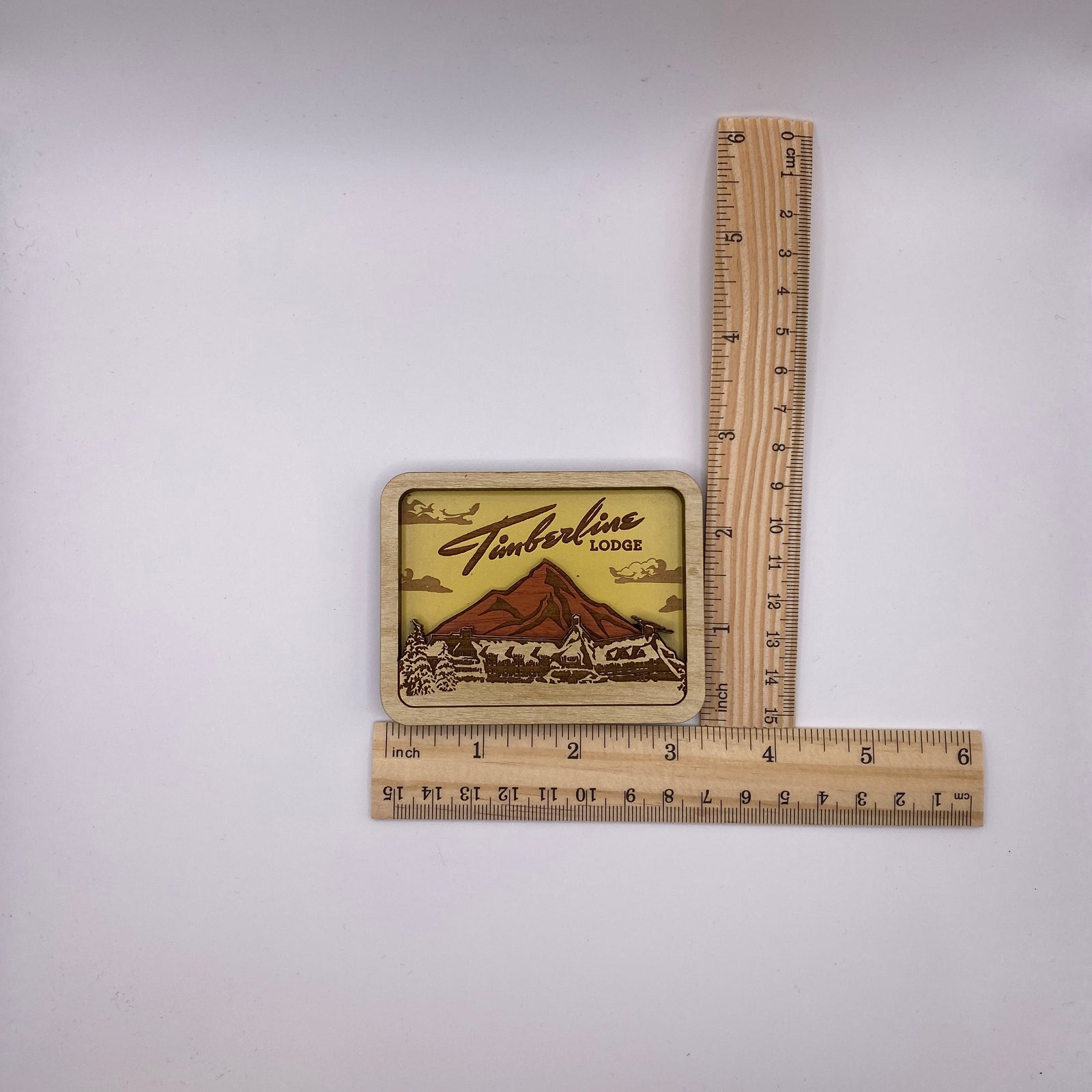 Wooden sign with 'Timberline Lodge' logo on a white background